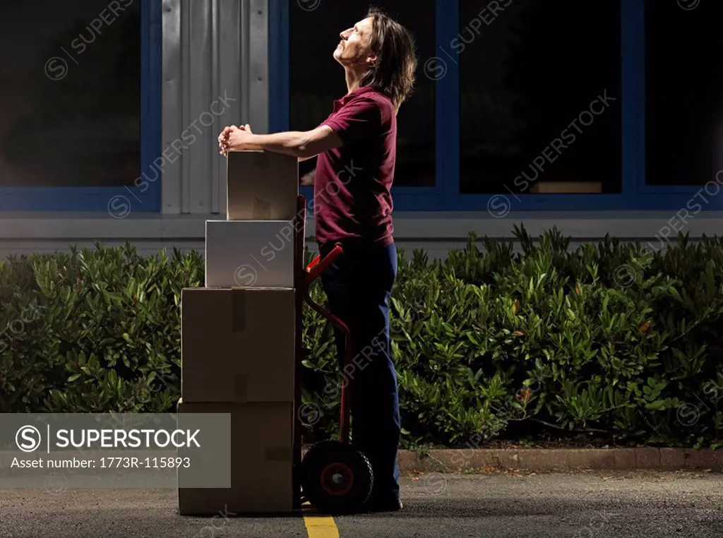 man moving boxes at night