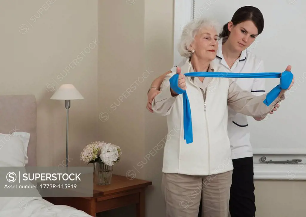 Nurse helping woman with exercises