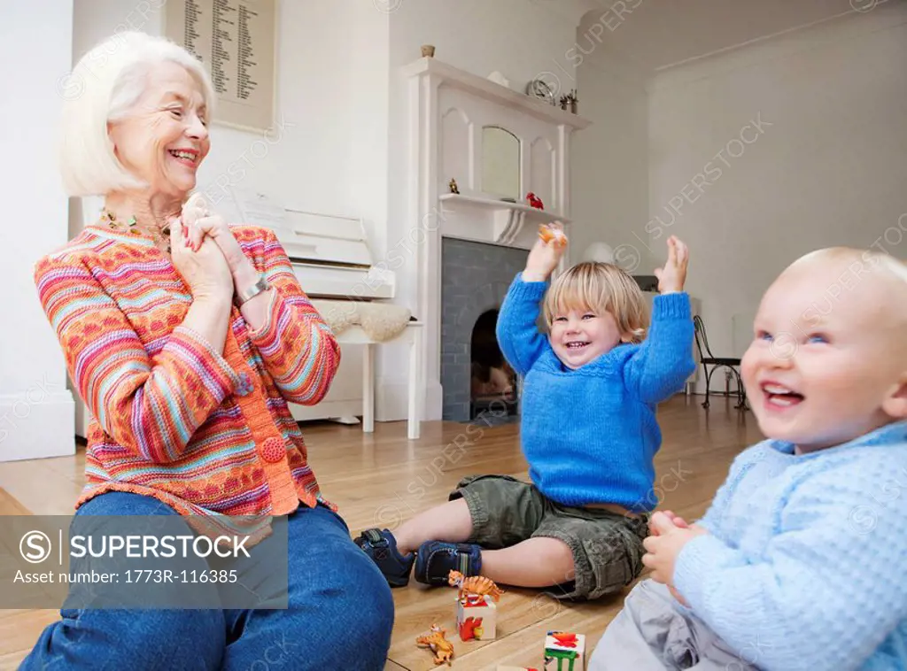 A grandmother playing with two toddlers