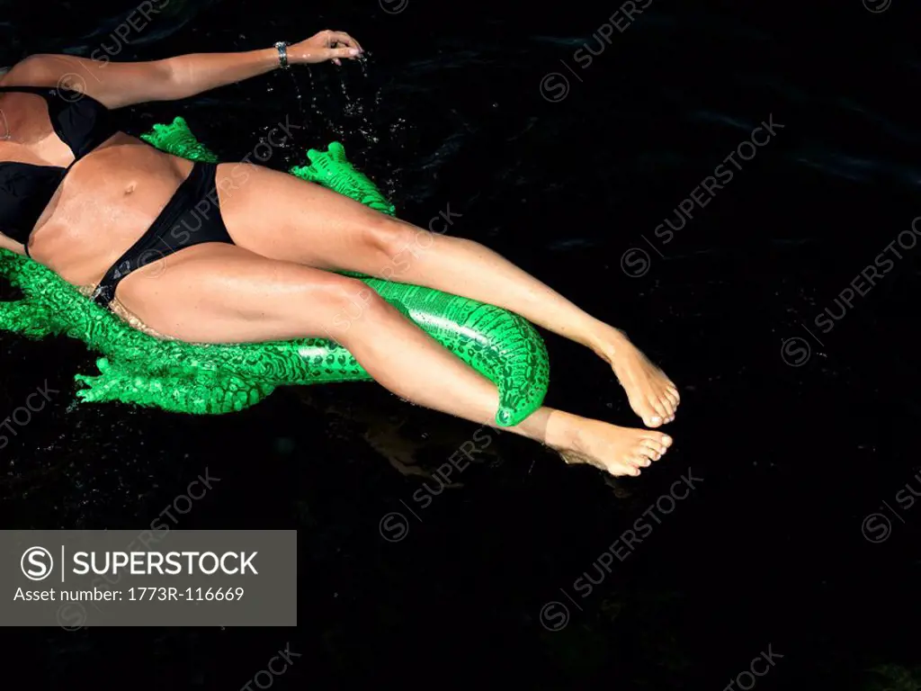 Woman on inflatable crocodile