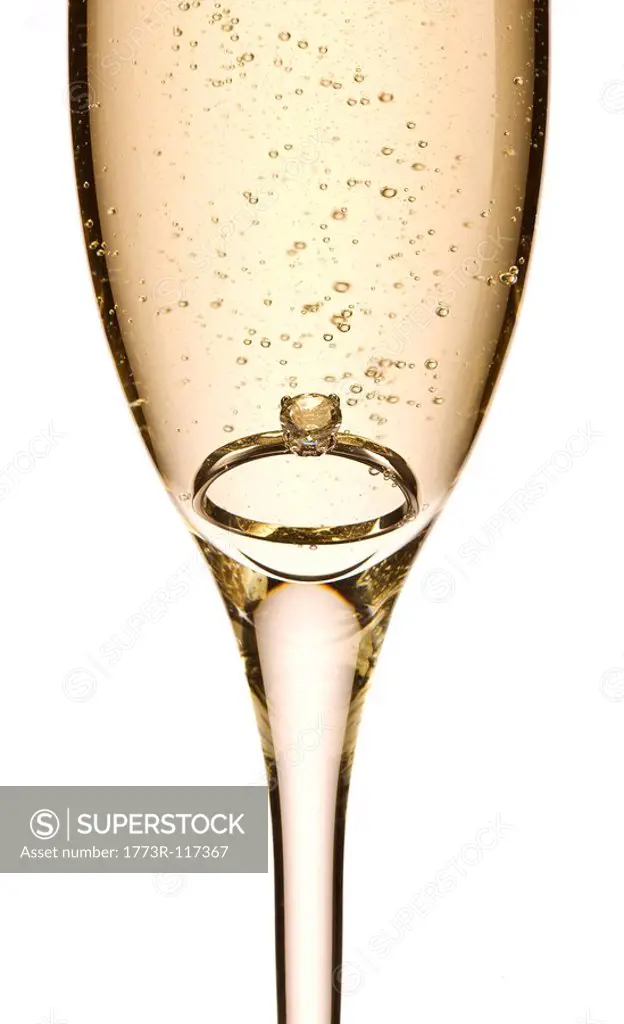 Engagement ring in glass of champagne