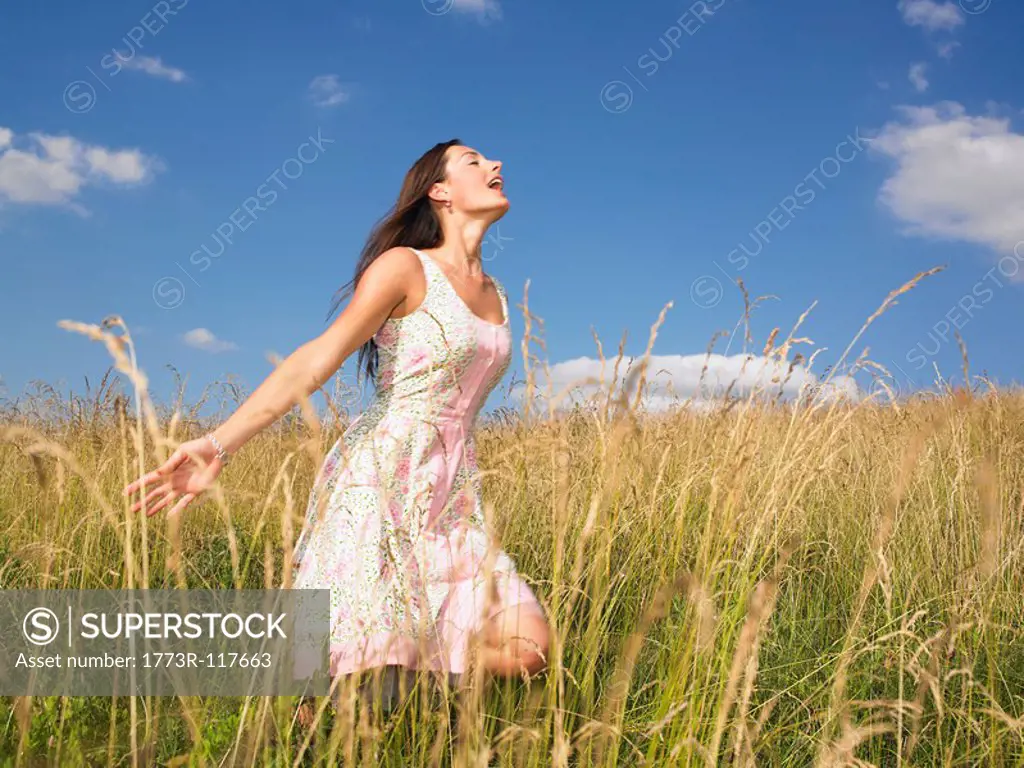 woman running in field of high grasses