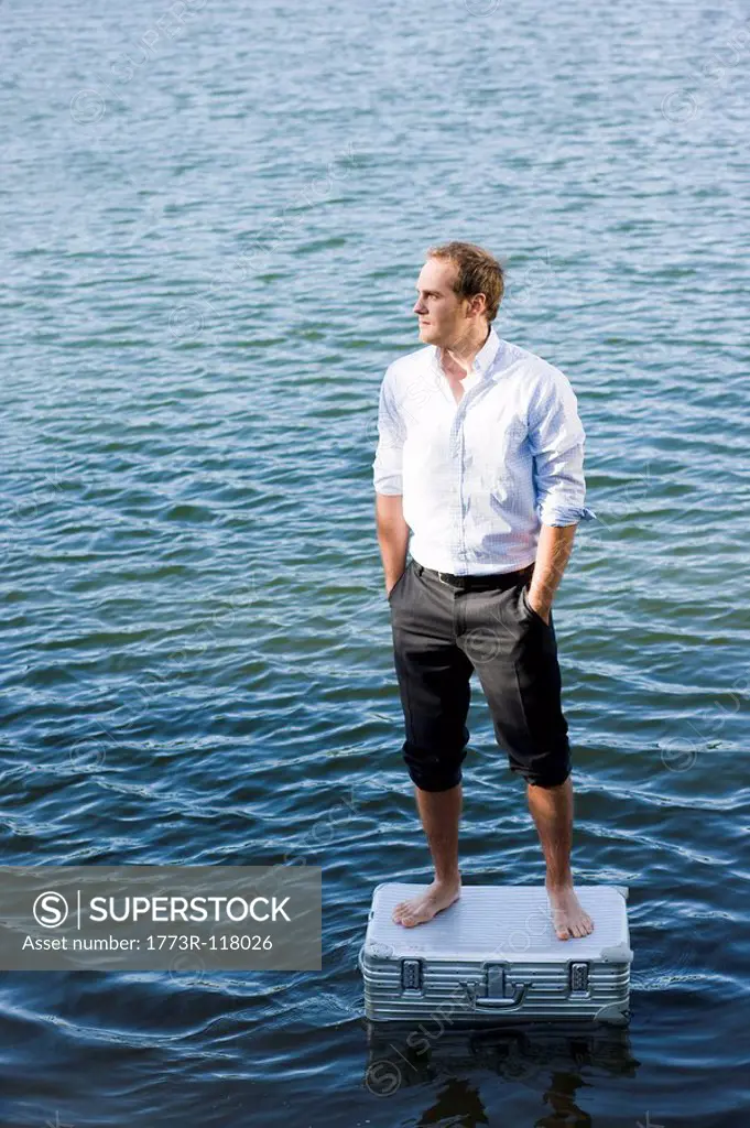 man standing on floating suitcase