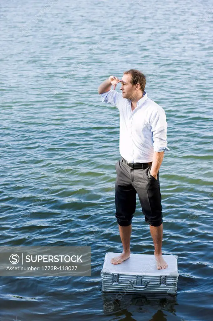 man standing on floating suitcase