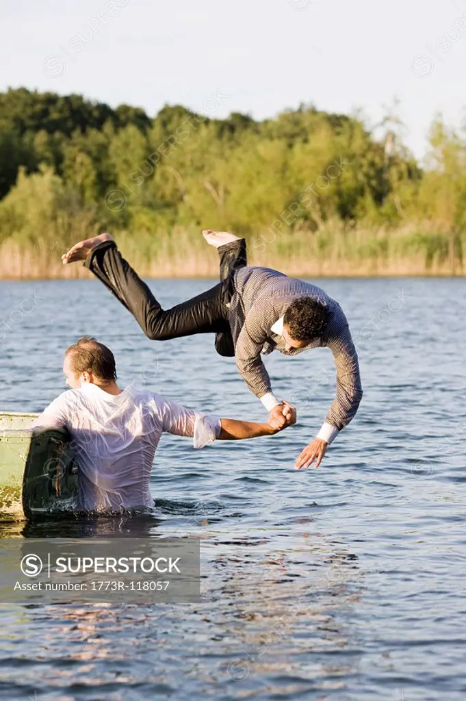 businessman throwing friend in water
