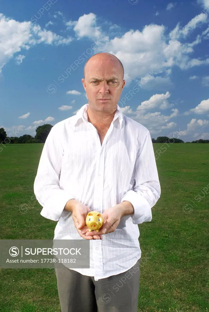 man holding small piggy bank