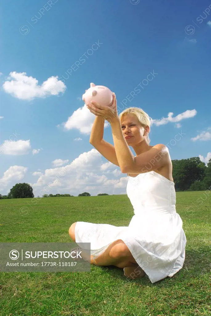 woman looking at piggy bank