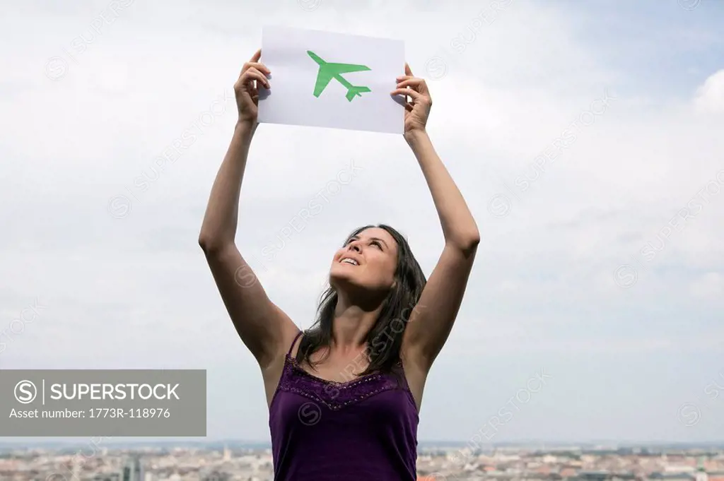 Woman lifting paper green plane