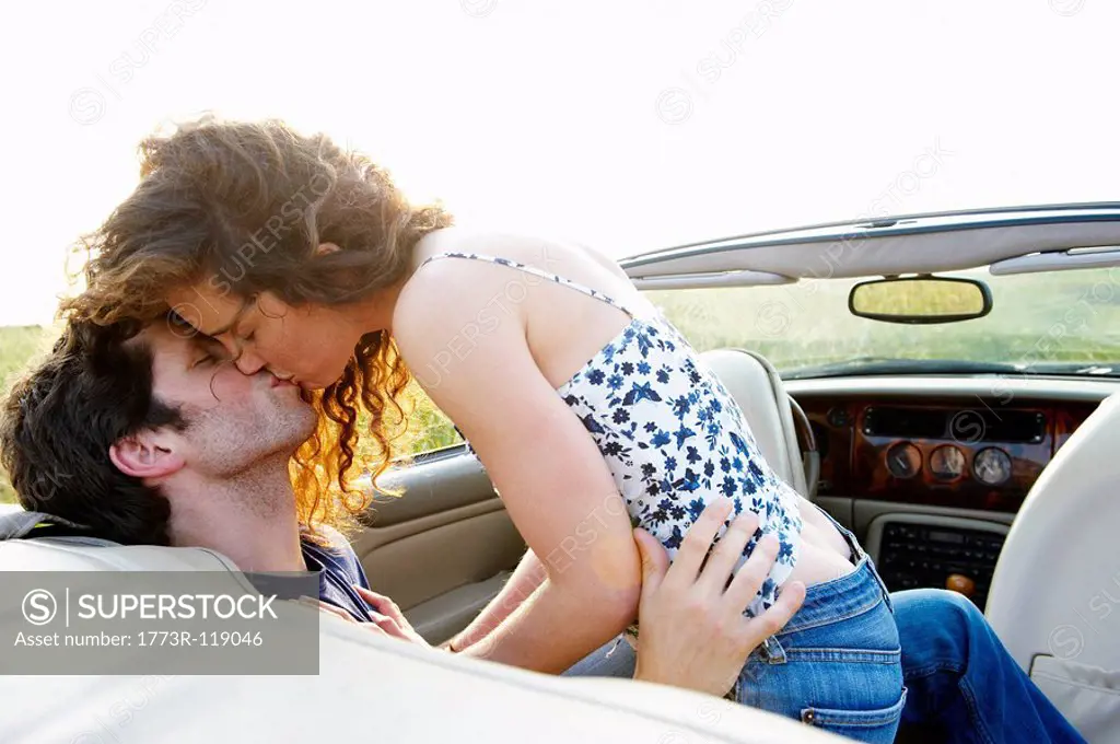 Couple kissing in a convertible