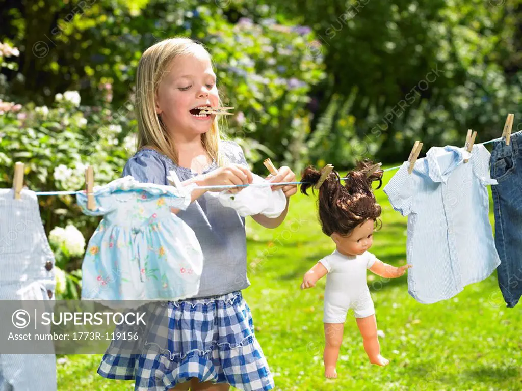 Girl spreading out her doll clothes