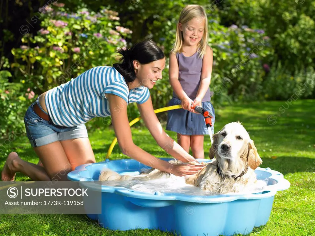 Mother and daughter washing the dog