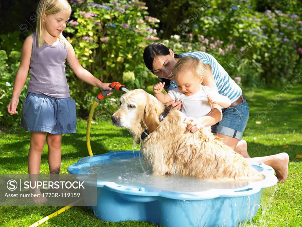 Mother, daughter and son washing the dog