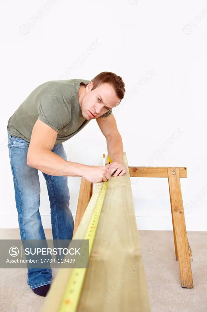Man measuring wooden plank