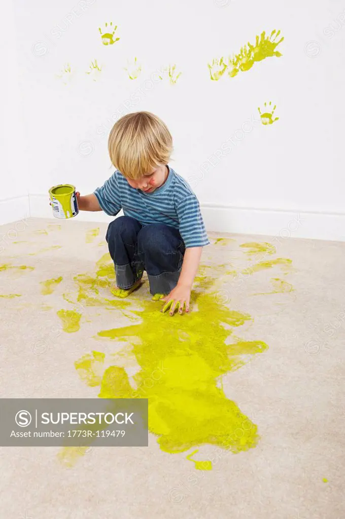 Boy sloshing paint onto carpet