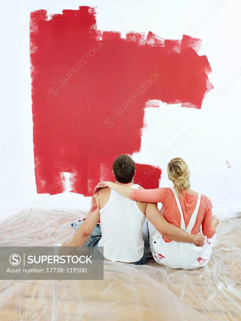 Couple contemplating painted wall