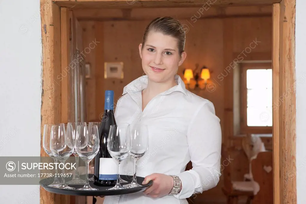 waitress with bottle of wine and glasses