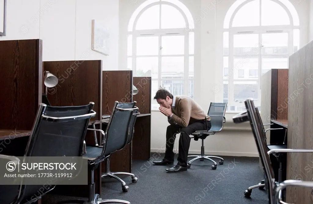 Young man at a workstation,worried