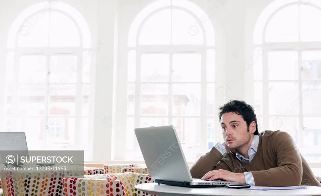 Young man gazing into laptop