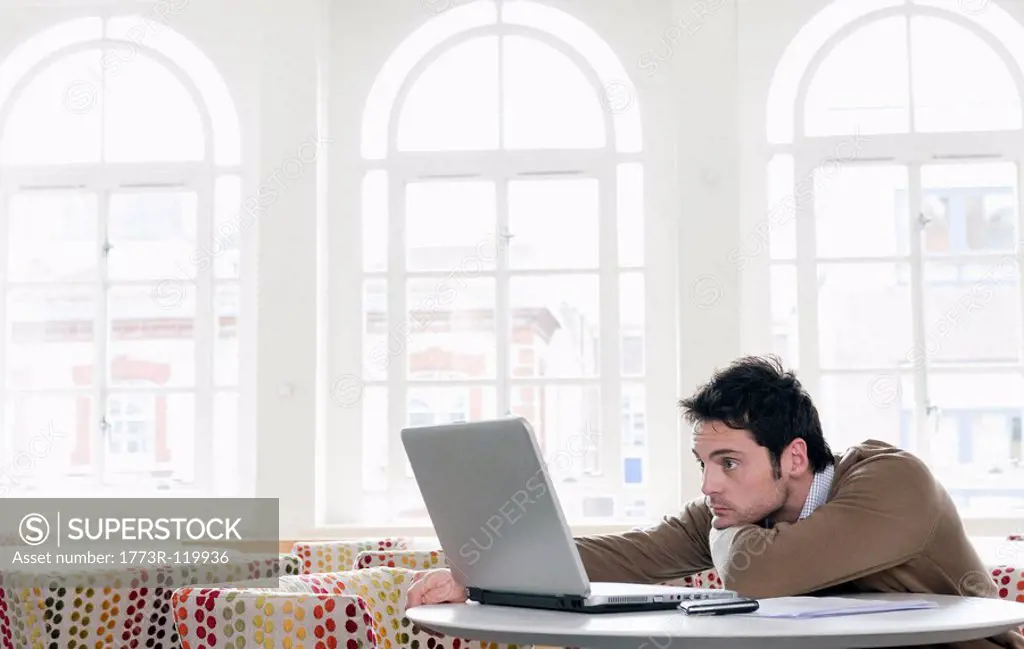 Young man gazing into laptop