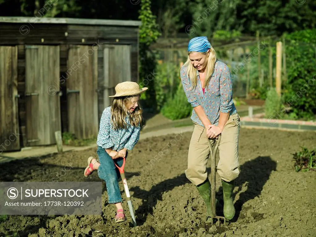 A woman and girl digging a garden