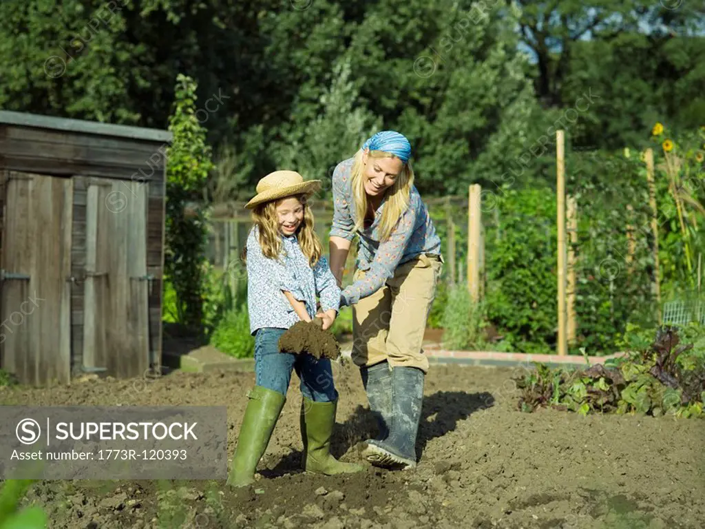 A woman and girl digging a garden