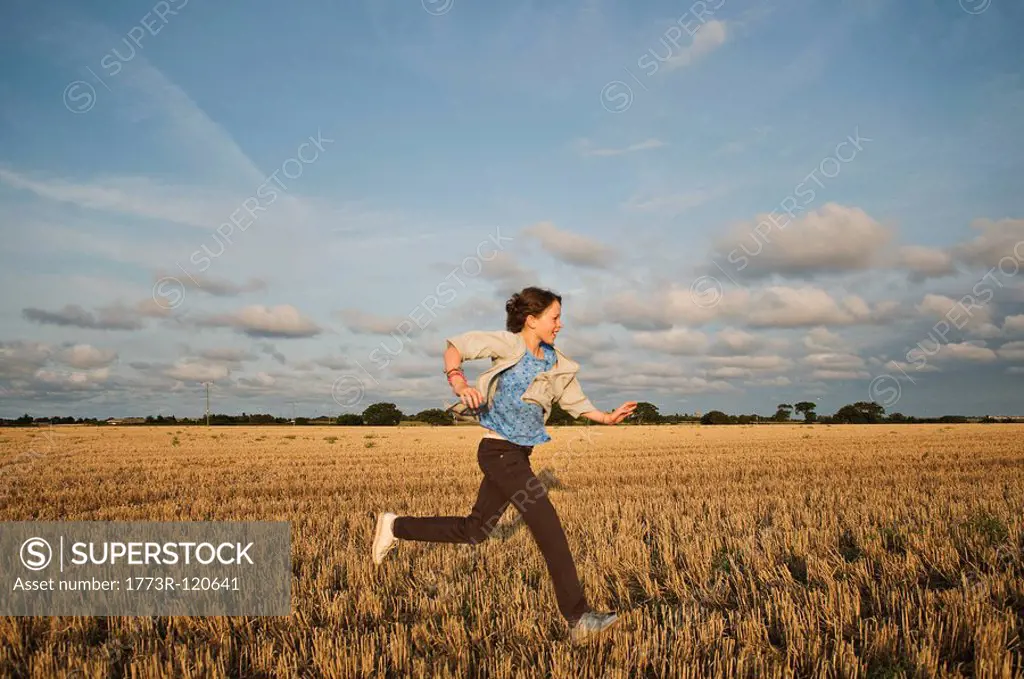 A young girl running through a field