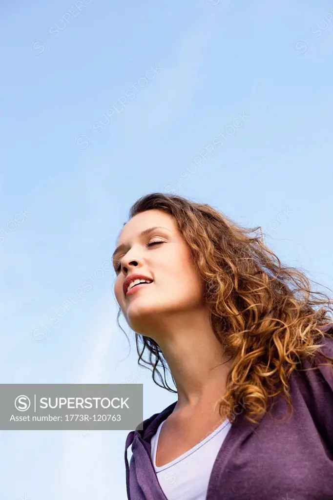 young woman under blue sky