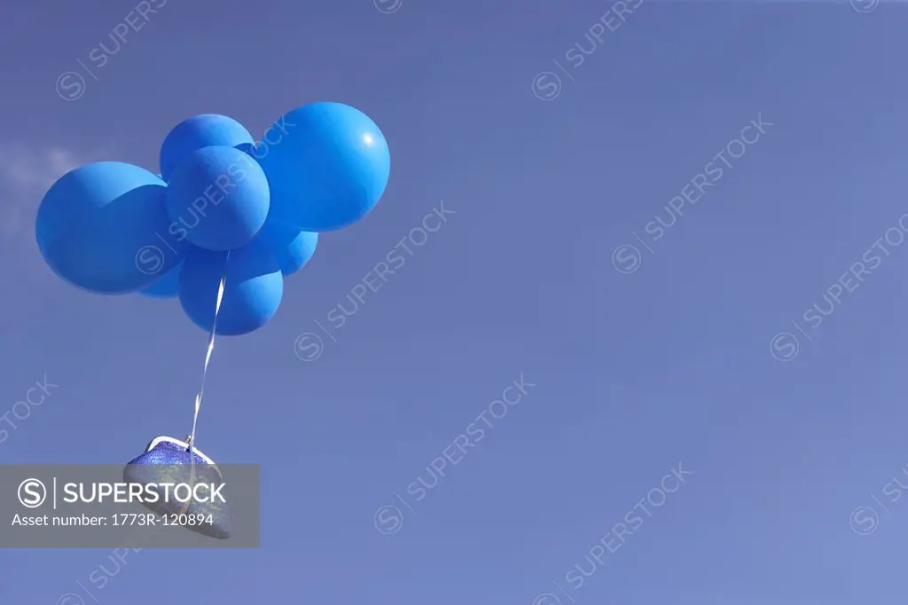 Blue purse flying with balloons