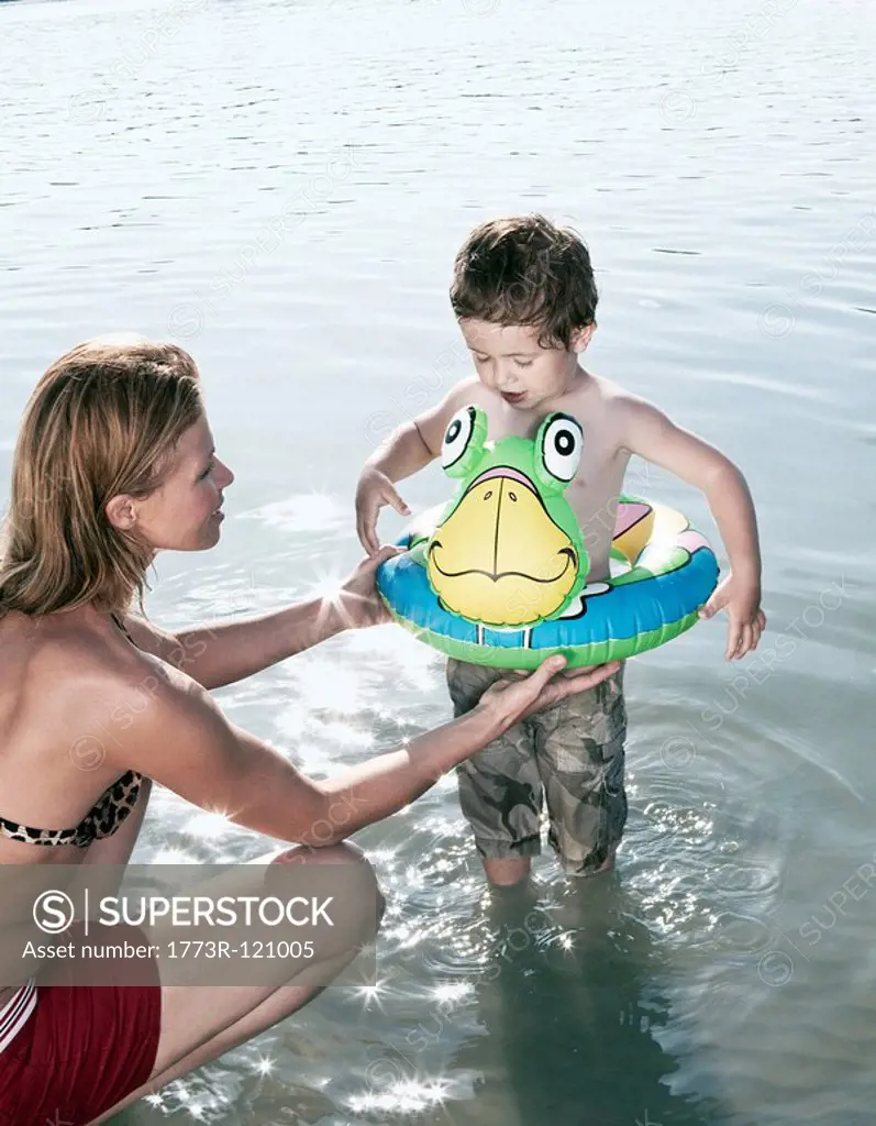 Mother fitting child´s swimming ring