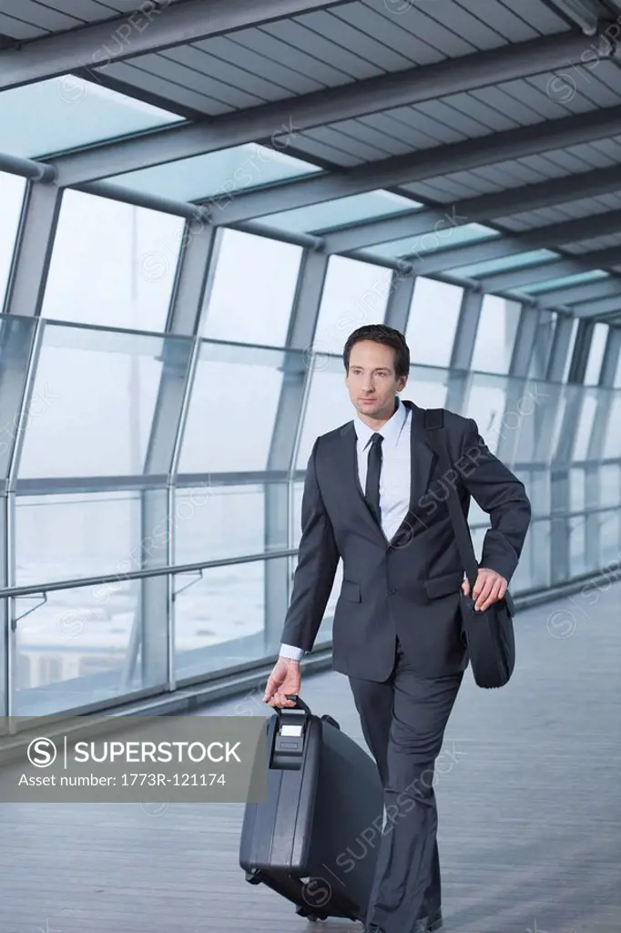 businessman with case walking in skywalk