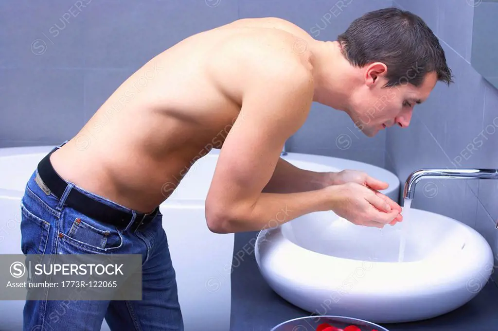 man bending in front of a tap