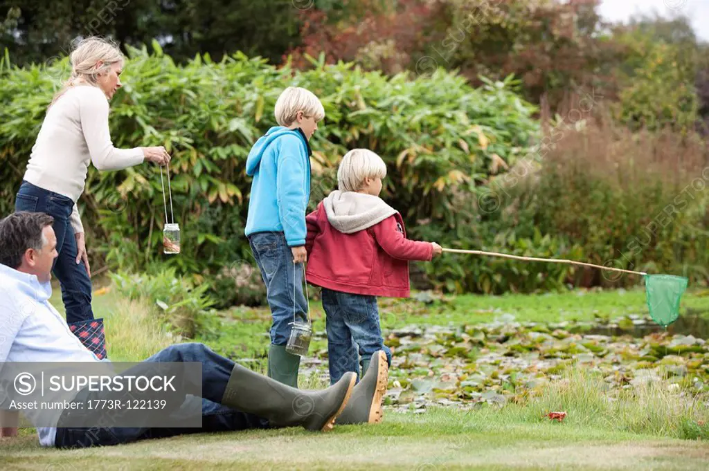 Family relaxing by pond