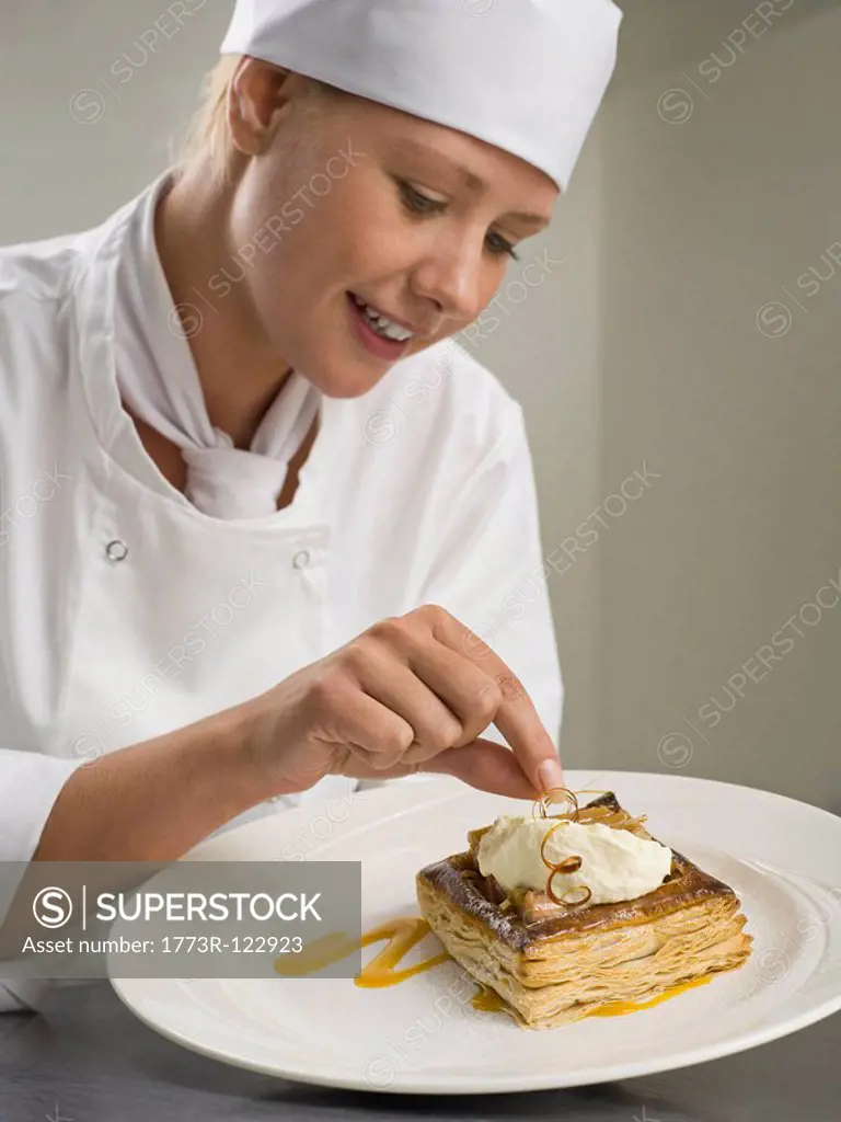 A female chef finishing a desert
