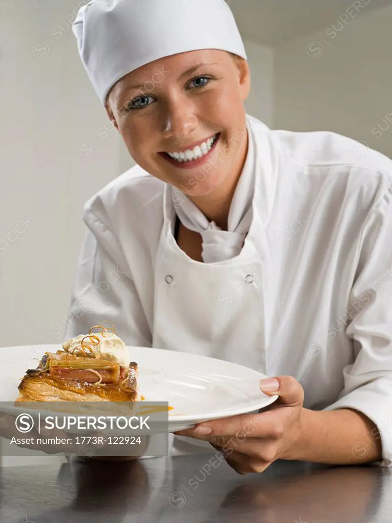 A female chef holding a pastry desert