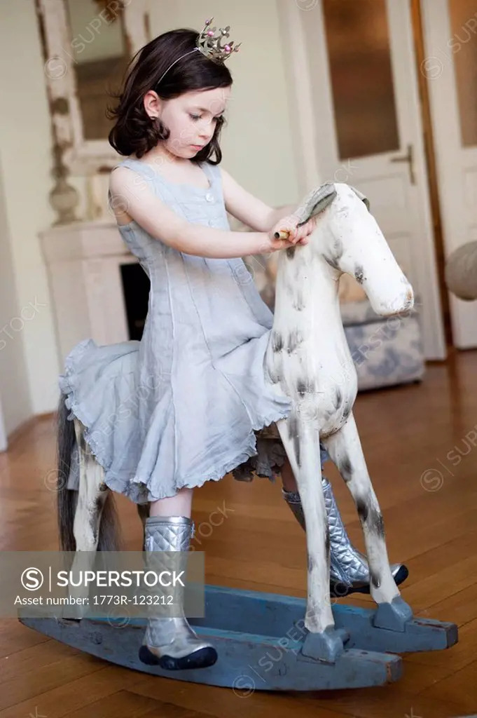 little girl riding a rocking horse