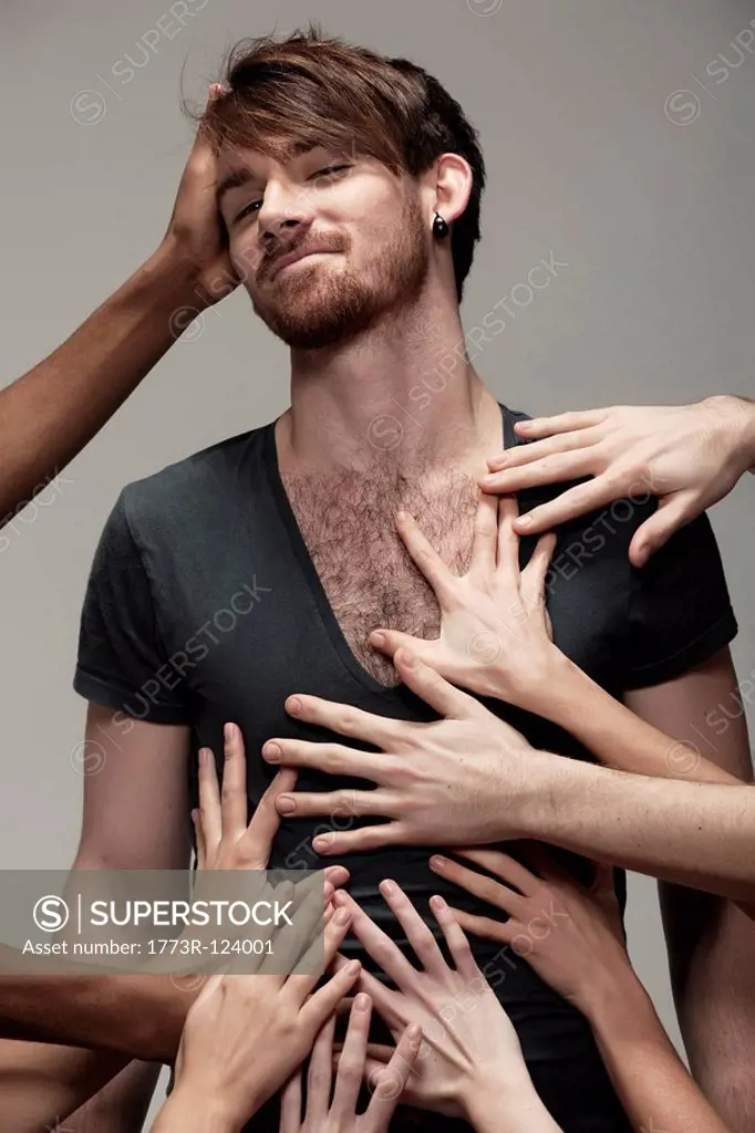 Young man being touched by hands
