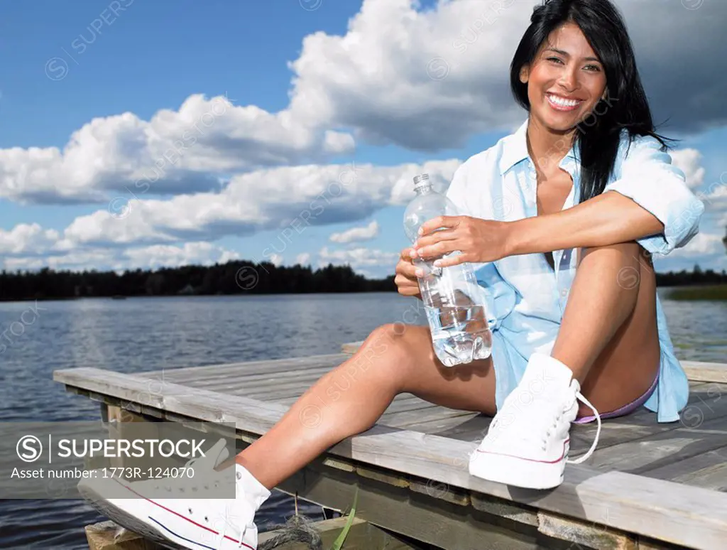 Woman with bottle of water, smiling