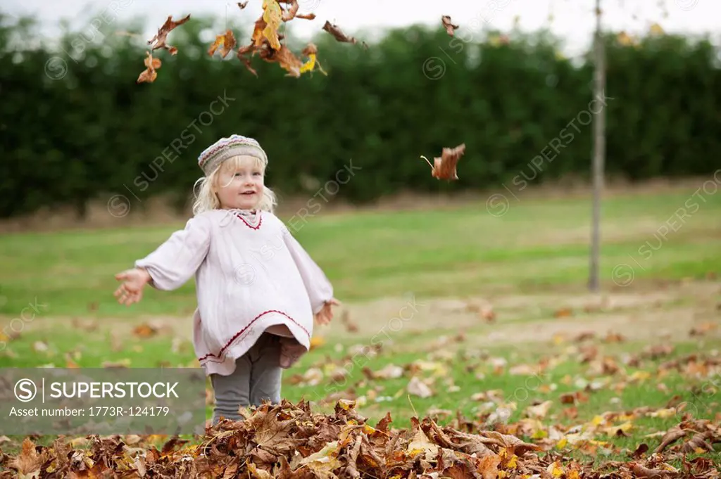Little girl throwing leaves in the air