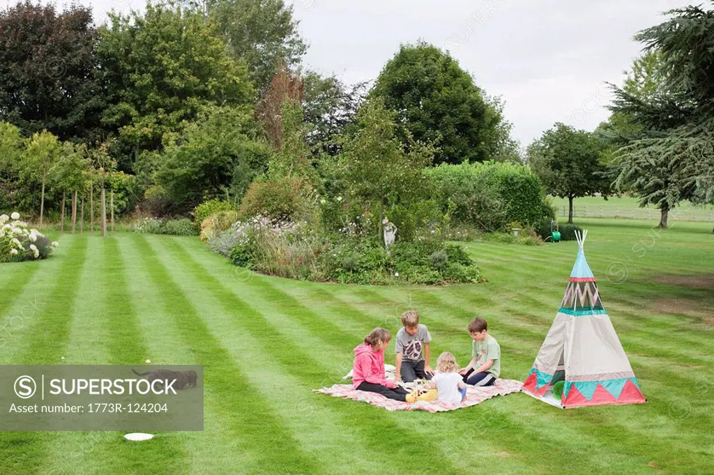 Children having picnic beside teepee