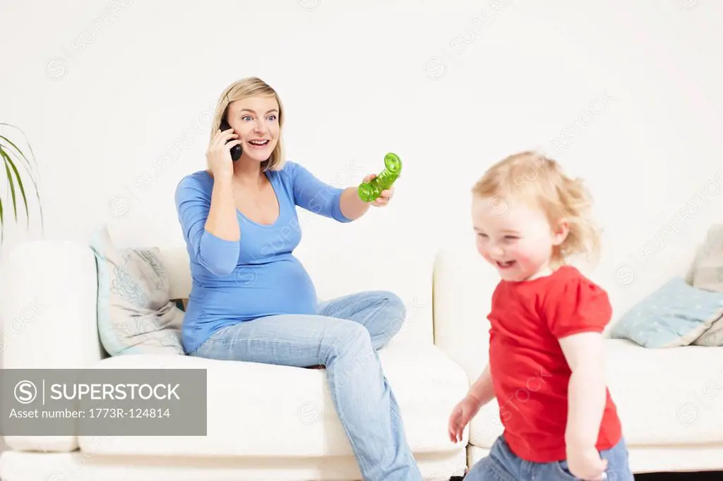 Pregnant woman on phone with toddler