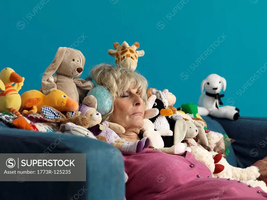 Mature woman asleep surrounded by toys