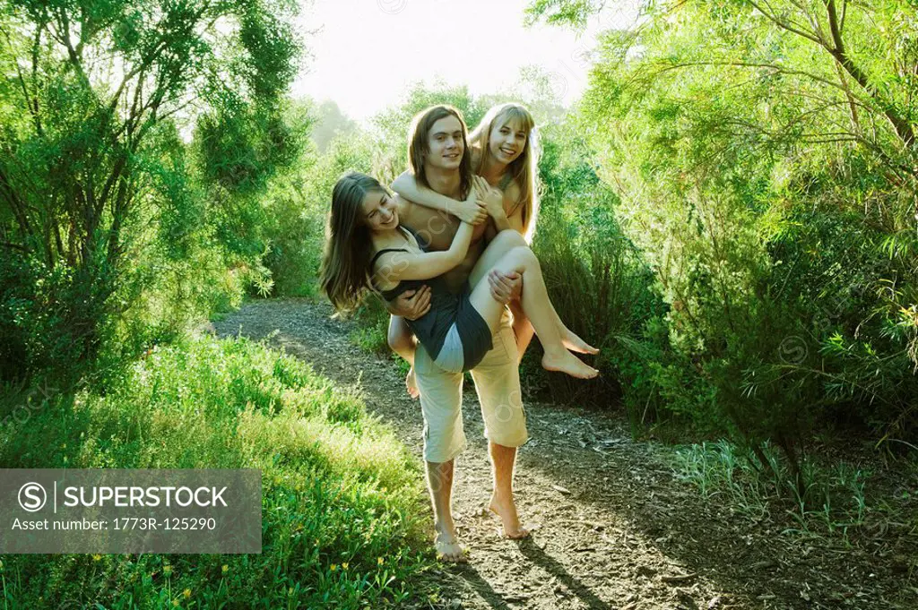 Young man carrying two young women