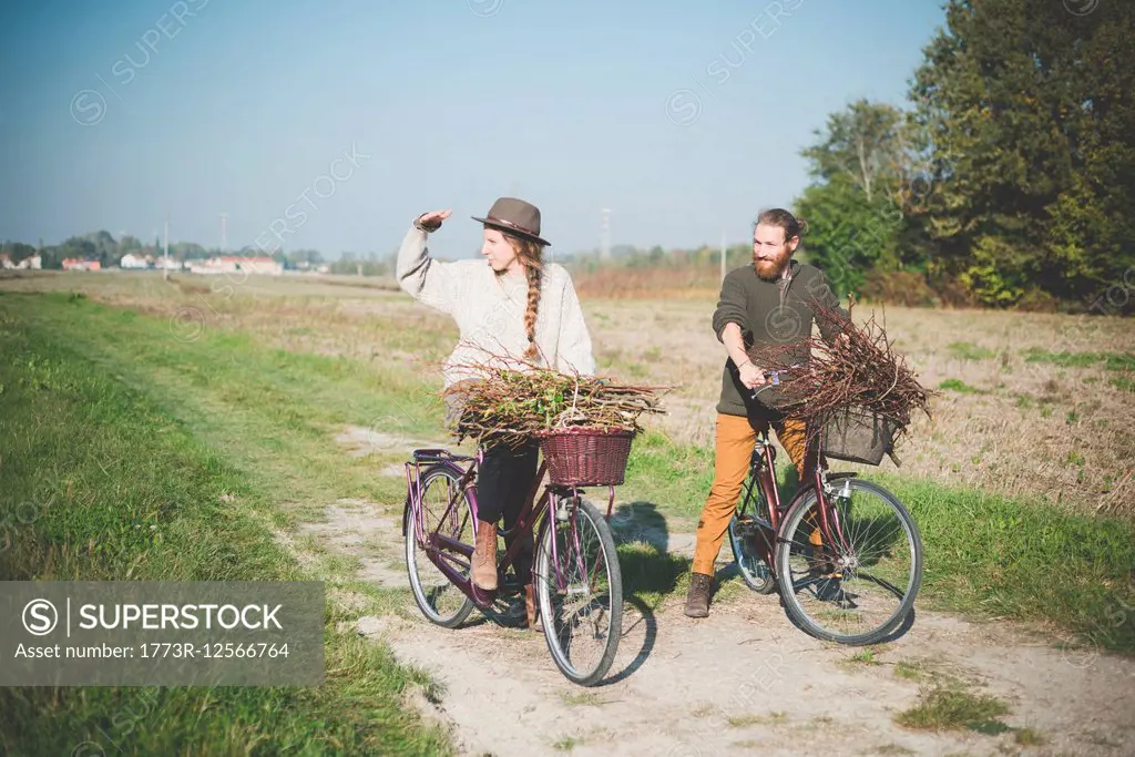 Young couple cycling in countryside, Dolo, Venice, Italy