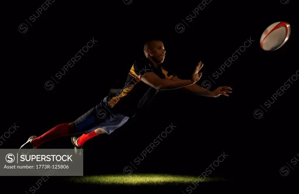 Rugby player diving whilst passing ball