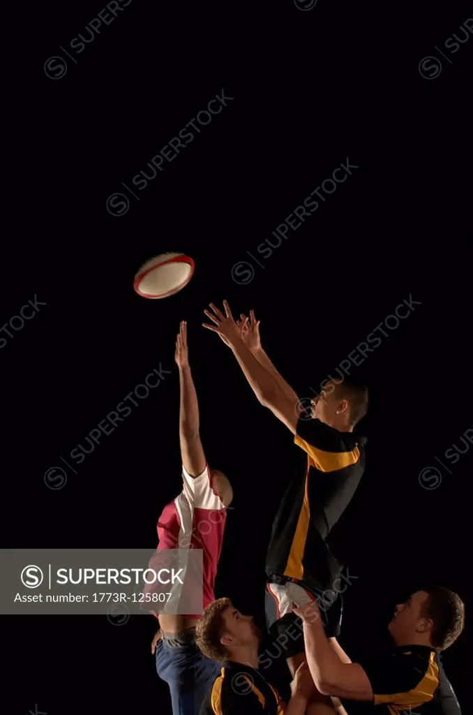 Rugby players jumping for ball
