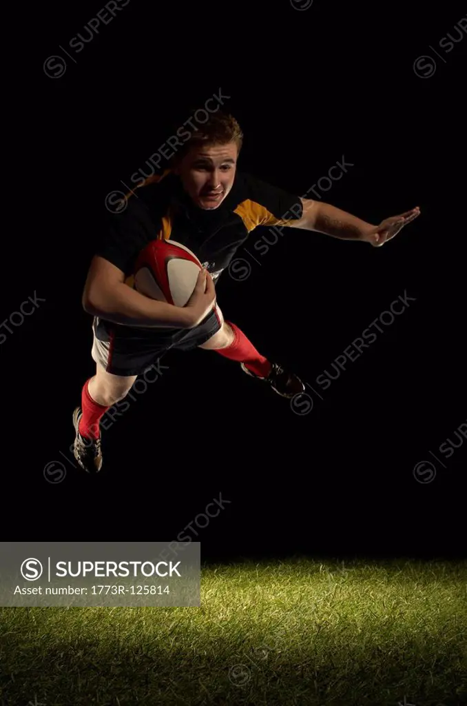 Rugby player mid air with ball