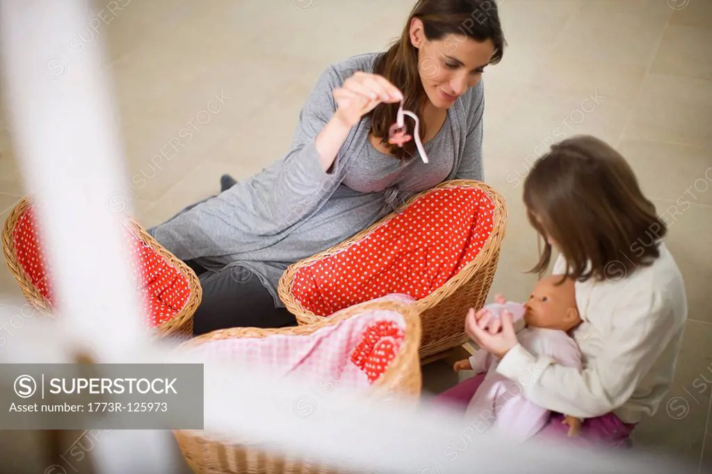 Pregnant woman playing with little girl