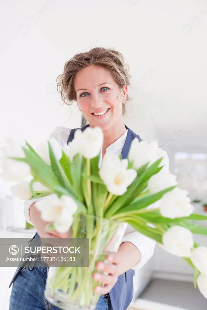 Woman holding a vase with white tulips