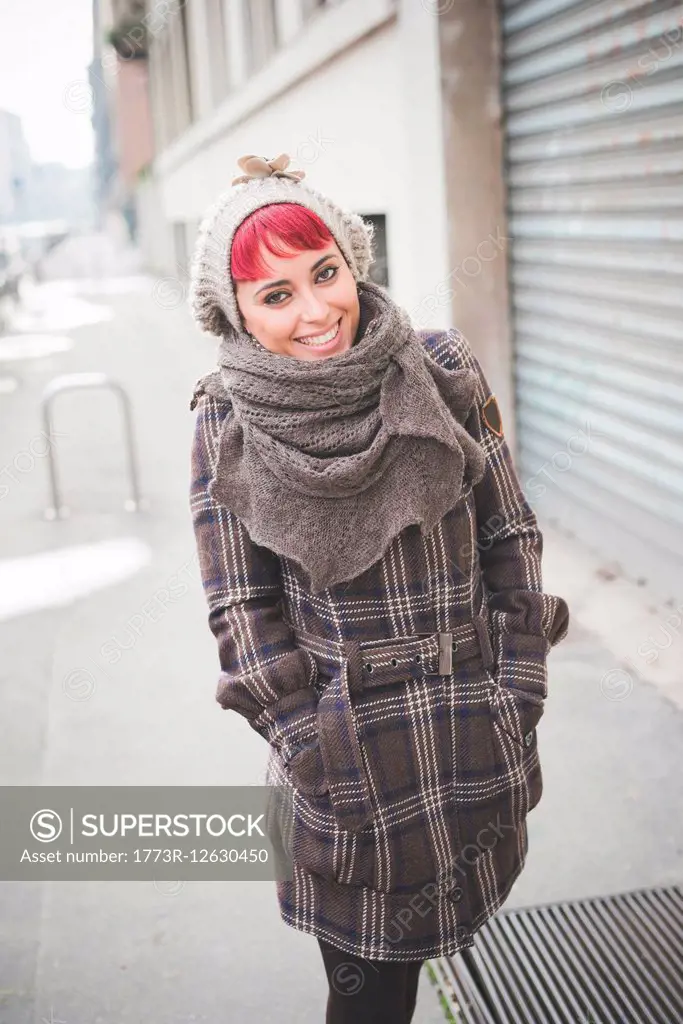 Portrait of young woman walking down street, wearing winter clothes