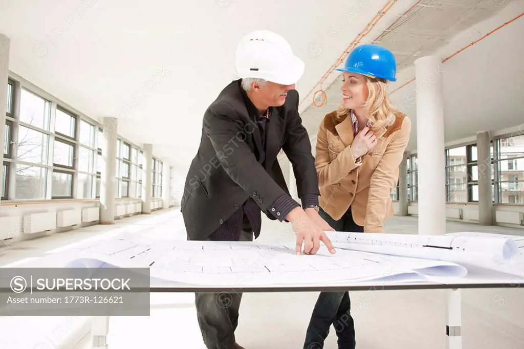 Two architects checking plans of site